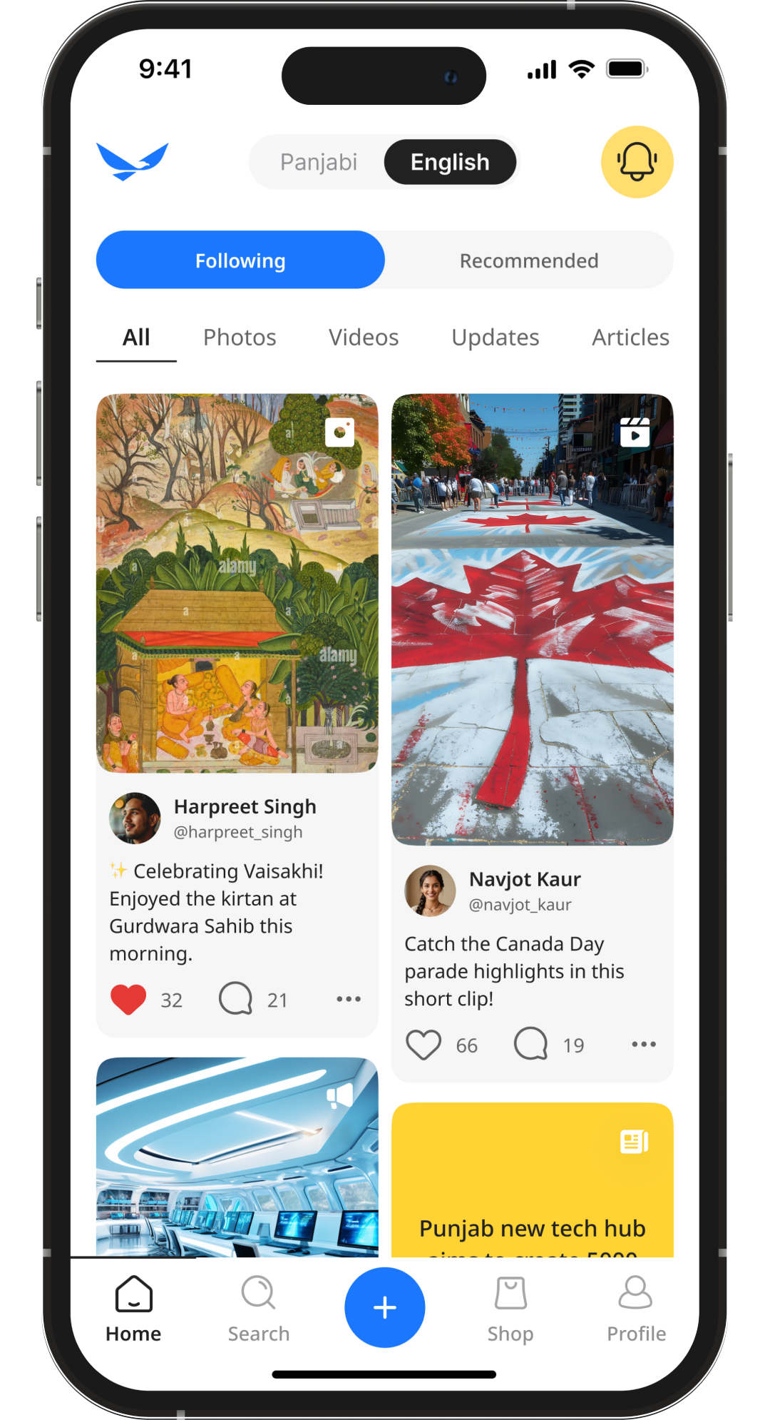 Bearded man in patterned shirt holding a camera, standing outdoors with trees and buildings in the background.